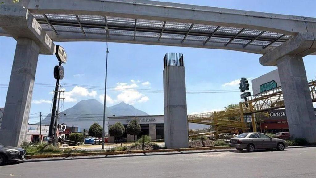 Street View Under a Large Concrete Overpass with a Metal Frame, Mountains in the Distance and a Few Cars on the Road. - Especies Políticas