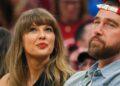 Woman with Long Light Brown Hair and Red Lipstick Looks Upward, Seated Beside a Bearded Man Wearing a Red Cap at a Crowded Event. - Especies Políticas