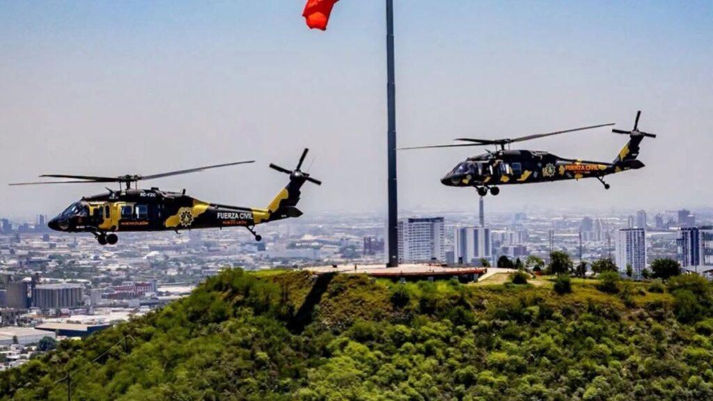 Two Black-and-yellow Helicopters Labeled Fuerza Civil Hover over a Hill with a City Skyline in the Background, a Flagpole Visible in the Scene. - Especies Políticas