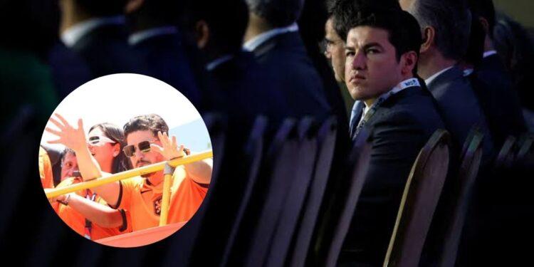 Audience in Formal Attire Sits at a Conference; Circular Inset Shows Orange-shirt Volunteers Raising Hands Behind a Railing. for Accessibility: Conveys Event Setting and the Inset Action of Volunteers Gesturing. - Especies Políticas