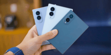 Person Holding Three Smartphones in Blue Shades, Showing Back with Triple-camera Modules on Each Phone. - Especies Políticas