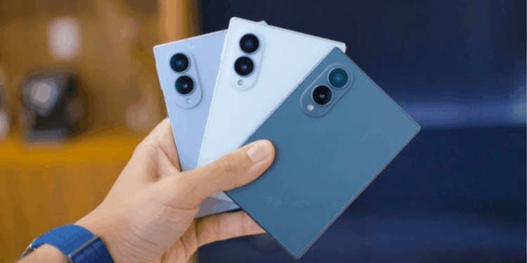 Person Holding Three Smartphones in Blue Shades, Showing Back with Triple-camera Modules on Each Phone. - Especies Políticas